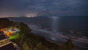A coastal view at night with a beach, a small resort area, and a clear moon in the sky. - Timurbay Seafront by My Seasons (Kuantan)