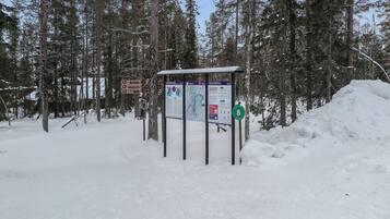 A snow-covered outdoor area with informational signs and a shelter.