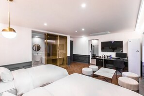 A modern hotel room with a large bed, a desk with a computer, a television, and a bathroom with a glass shower enclosure. - Brown Dot Hotel Sasang Renecite (Busan)