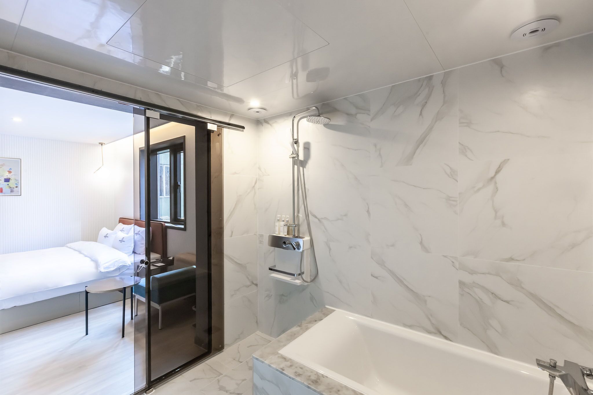 Une salle de bain moderne avec un mur en marbre, une baignoire et une douche.