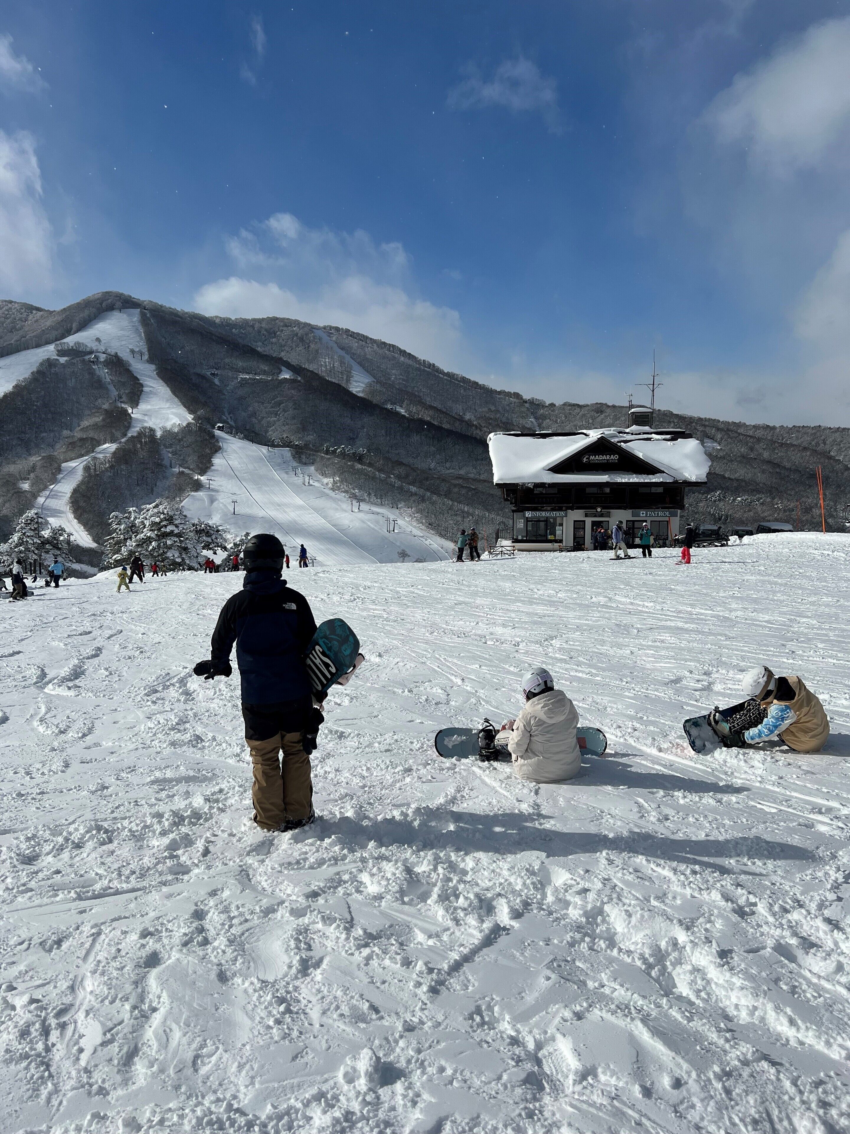 A snow-covered ski slope with a lodge in the background.