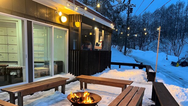 A wooden deck with benches and a fire pit, surrounded by snow. - Ringo Jam Madarao (Myoko)