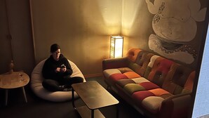 A room with a couch, a small table, and a lamp. There is a wall with a mural. - Ringo Jam Madarao (Myoko)