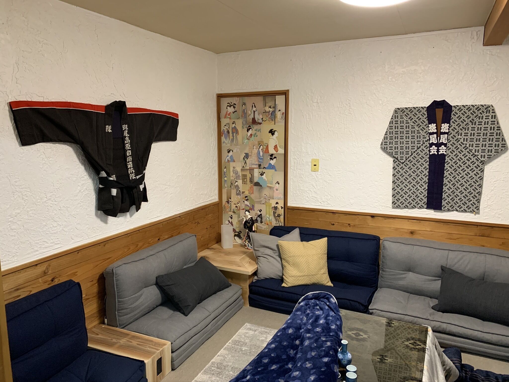 Olohuone, jossa on sohva, sohvapöytä ja seinälle kiinnitetty naulakko.