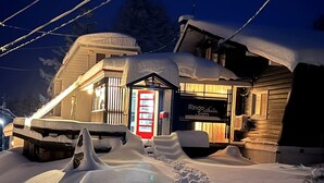 A snow-covered building with a visible entrance and signage for 'Ringo Jam'. - Ringo Jam Madarao (Myoko)