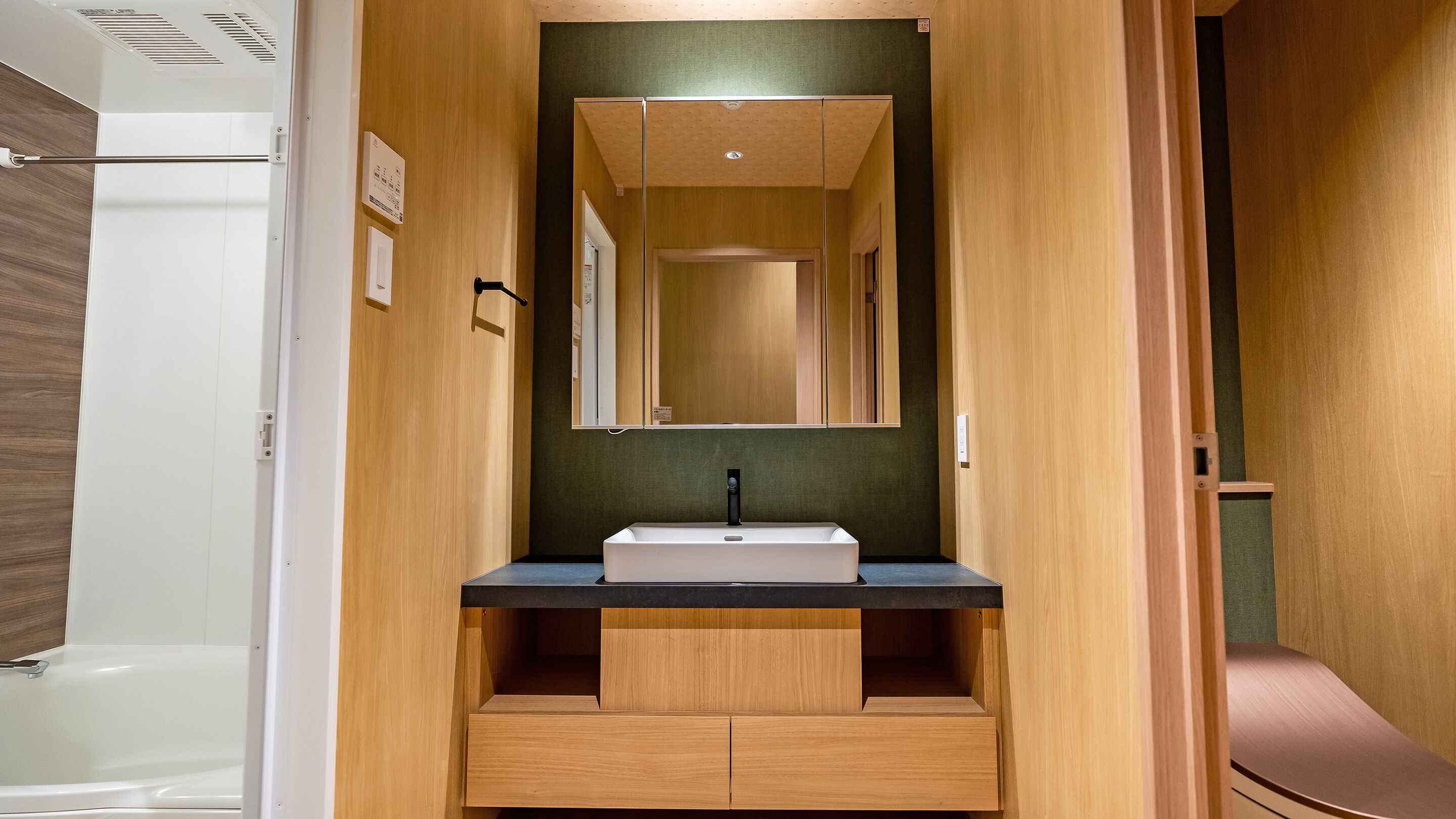 Un baño moderno con un mueble de tocador de madera, un lavabo y un espejo.