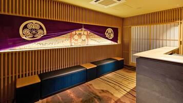 A modern bar area with a wooden slat wall, a bench, and a counter.