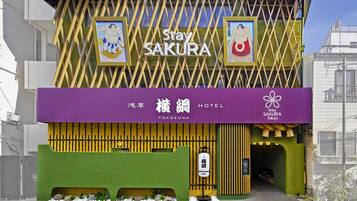 Eine Hotelscheune mit Schildern für "Stay Sakura Tokyo" und "Yokozuna Hotel".