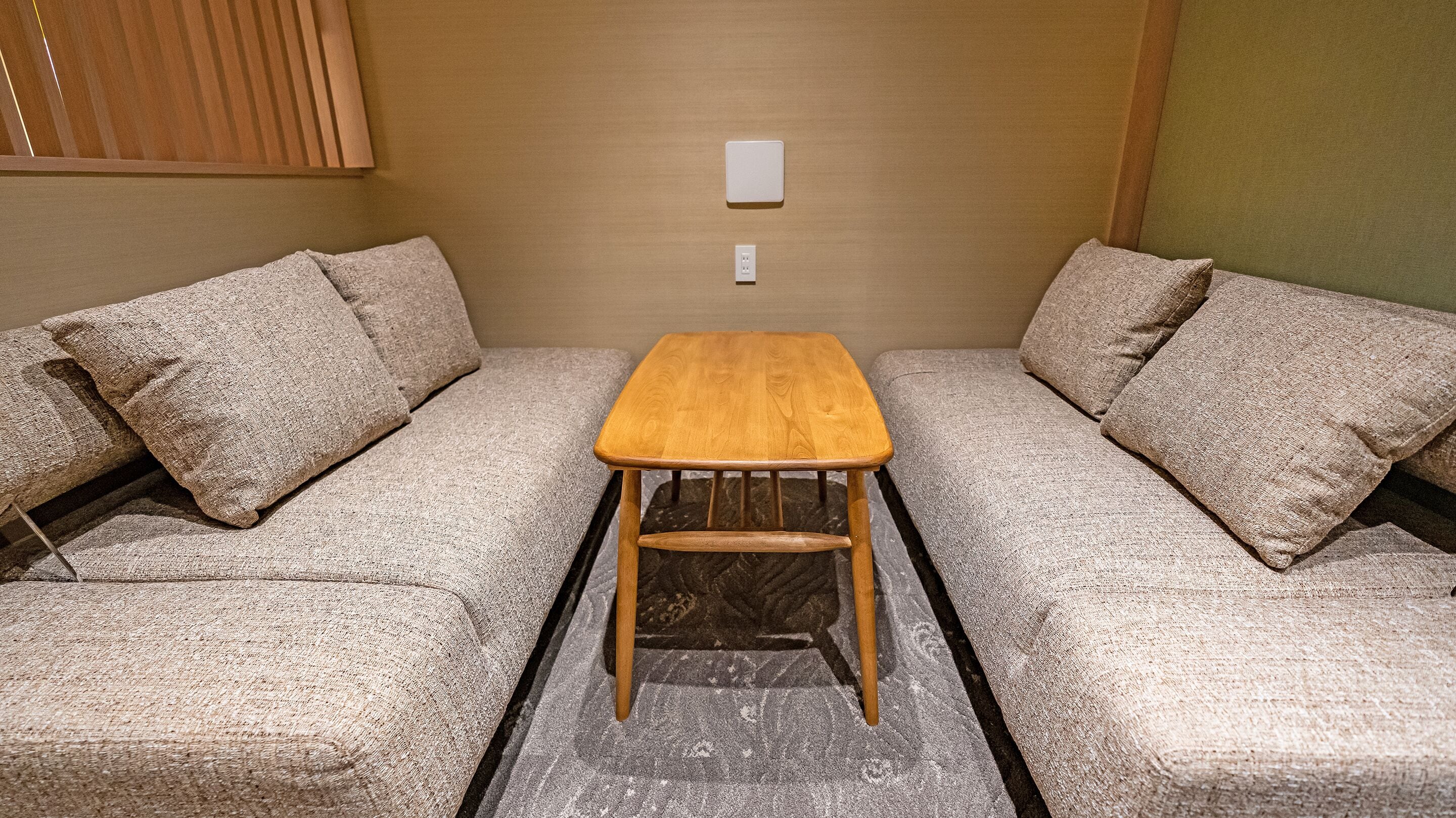 A compact living space with a wooden table and two sofas.