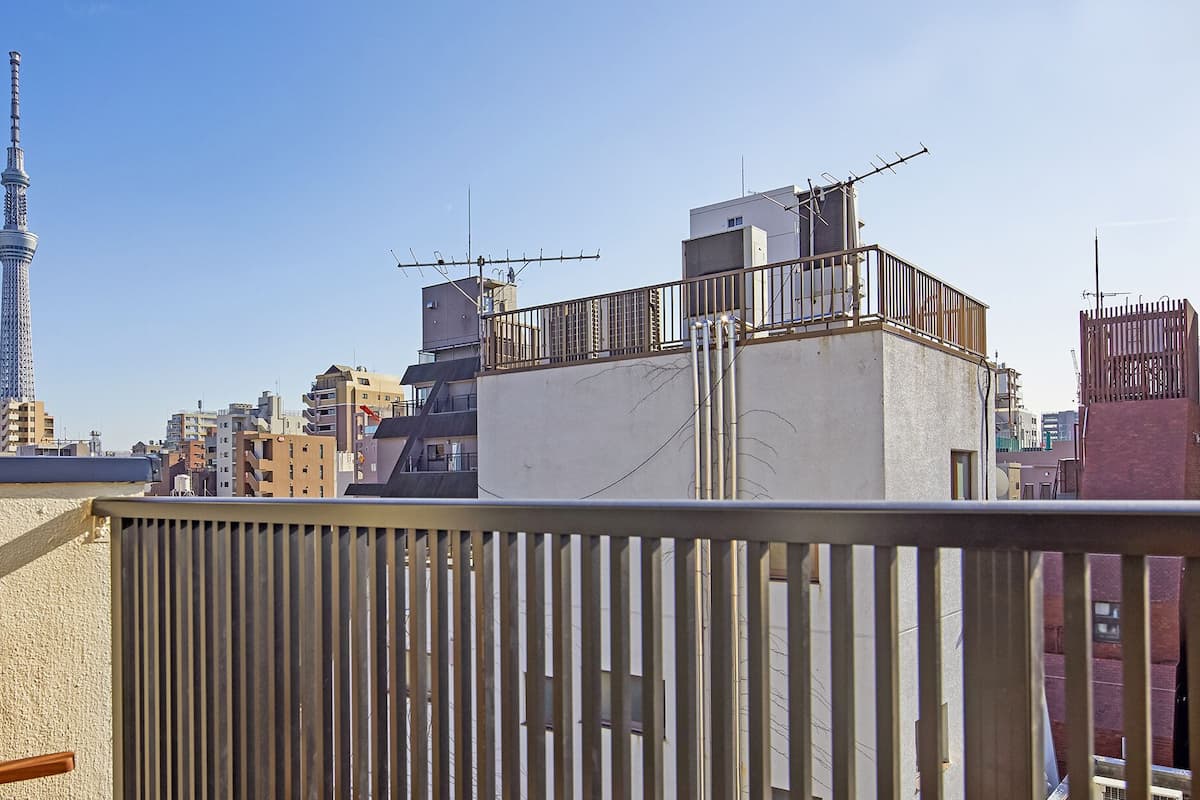 A balcony with a view of a cityscape, including a tall tower.