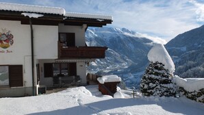 Un edificio cubierto de nieve con un balcón que da a un paisaje montañoso.