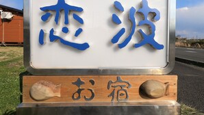 A sign with Japanese characters and a wooden base with seashells. - Koinami (Shima)