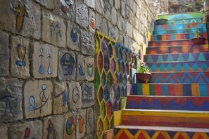 A staircase with colorful geometric patterns and painted figures on the wall. - Saigonese Trekking House - Hostel (Sa Pa)