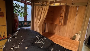 A bedroom with a bed, wooden wardrobe, and a window with curtains. - Saigonese Trekking House - Hostel (Sa Pa)