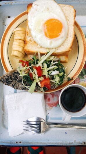 A plate with a fried egg, banana, and a salad on a tray. - Saigonese Trekking House - Hostel (Sa Pa)