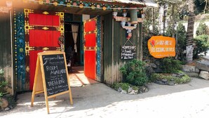A rustic trekking house with a colorful entrance, a signboard advertising room availability, and a trekking sign. - Saigonese Trekking House - Hostel (Sa Pa)
