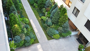 Eine Luftaufnahme eines Innenhofs mit einem zentralen, kreisförmigen Garten, umgeben von mehrstöckigen Gebäuden mit Balkonen und Fenstern.
