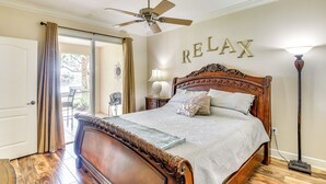 A bedroom with a large bed, a ceiling fan, a 'RELAX' sign on the wall, and a floor lamp. - Resort-Style Perks! Riverfront Gem in Palm Coast (Palm Coast)