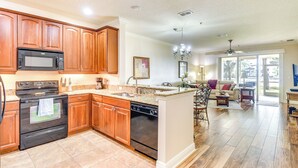 A kitchen with wooden cabinets, a microwave, stove, and dishwasher. - Resort-Style Perks! Riverfront Gem in Palm Coast (Palm Coast)