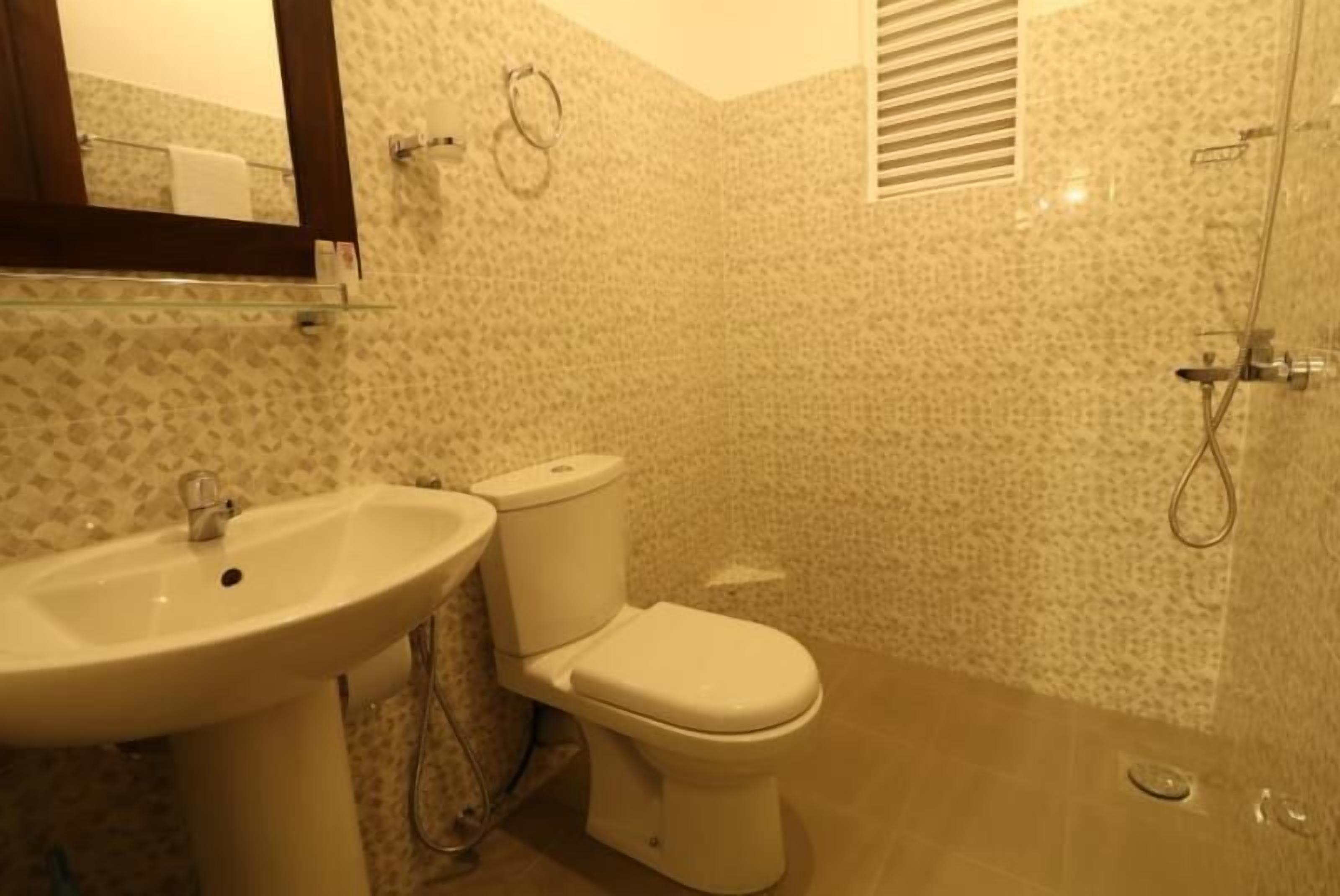 Een badkamer met een wastafel, toilet en douche.