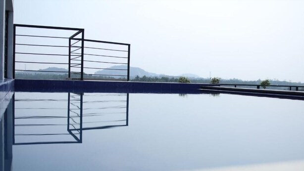 A serene indoor pool with a clear view of distant mountains. - Sky 14 Hotel Apartments (Malabe)