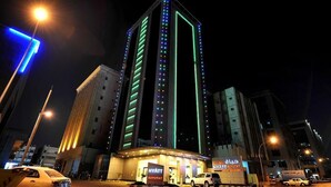 Un hotel de diseño moderno, con una llamativa barra de luz vertical y un letrero que indica que es un Hyatt Buyutat.