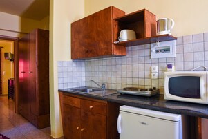 Una cocina con armarios de madera, microondas, cafetera y lavavajillas.