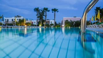 Una piscina al aire libre de temporada, sillones reclinables de piscina