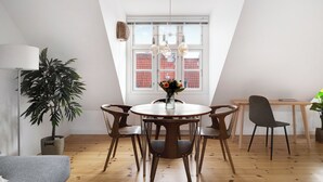 A dining area with a round table, chairs, a vase with flowers, a lamp, and a potted plant. - Saint - Nice 1-bdr Apt by the Canals (Copenhagen)