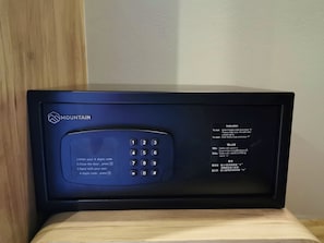 Een zwart elektronisch apparaat met een keypad en instructies in verschillende talen.