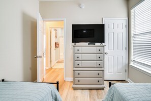 2 habitaciones, escritorio y tabla de planchar con plancha