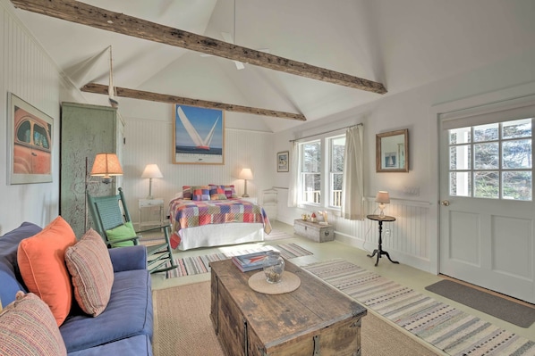 A cozy bedroom with a bed, a wooden chest, and a blue sofa.