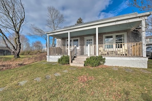 A two-story house with a covered porch, a front yard with a stone pathway, and a small garden area.