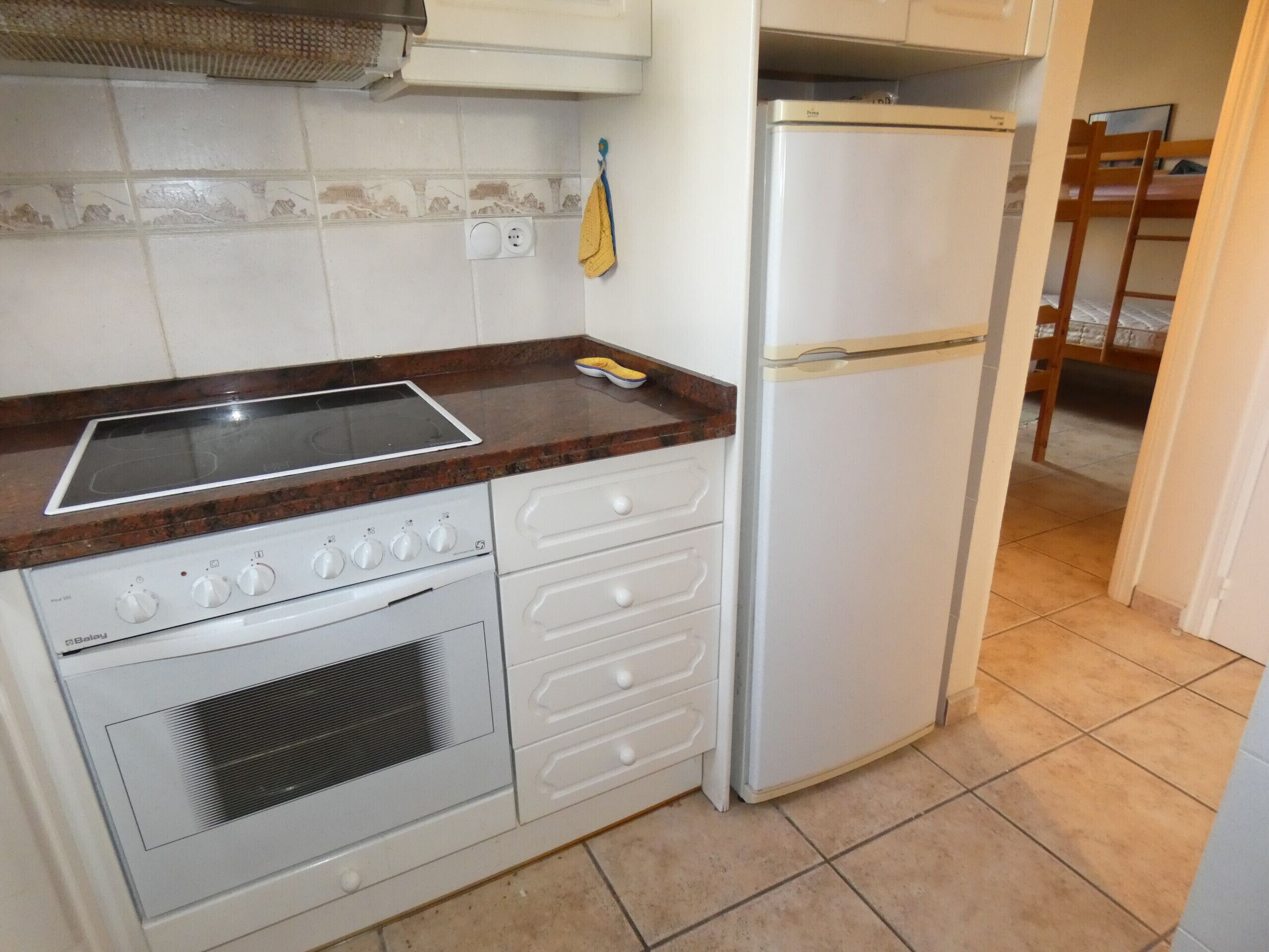 A compact kitchen with a stove, oven, and a refrigerator.