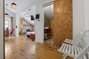Een modern interieur met een houten vloer, een bed, een bureau en een witte stoel.