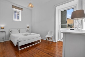 A modern bedroom with a bed, bedside lamps, a chair, a desk, and a window. - Saint Paul, Third Floor (Lisboa)