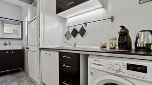 Una cocina moderna con lavavajillas integrado, un lavabo y una cafetera.