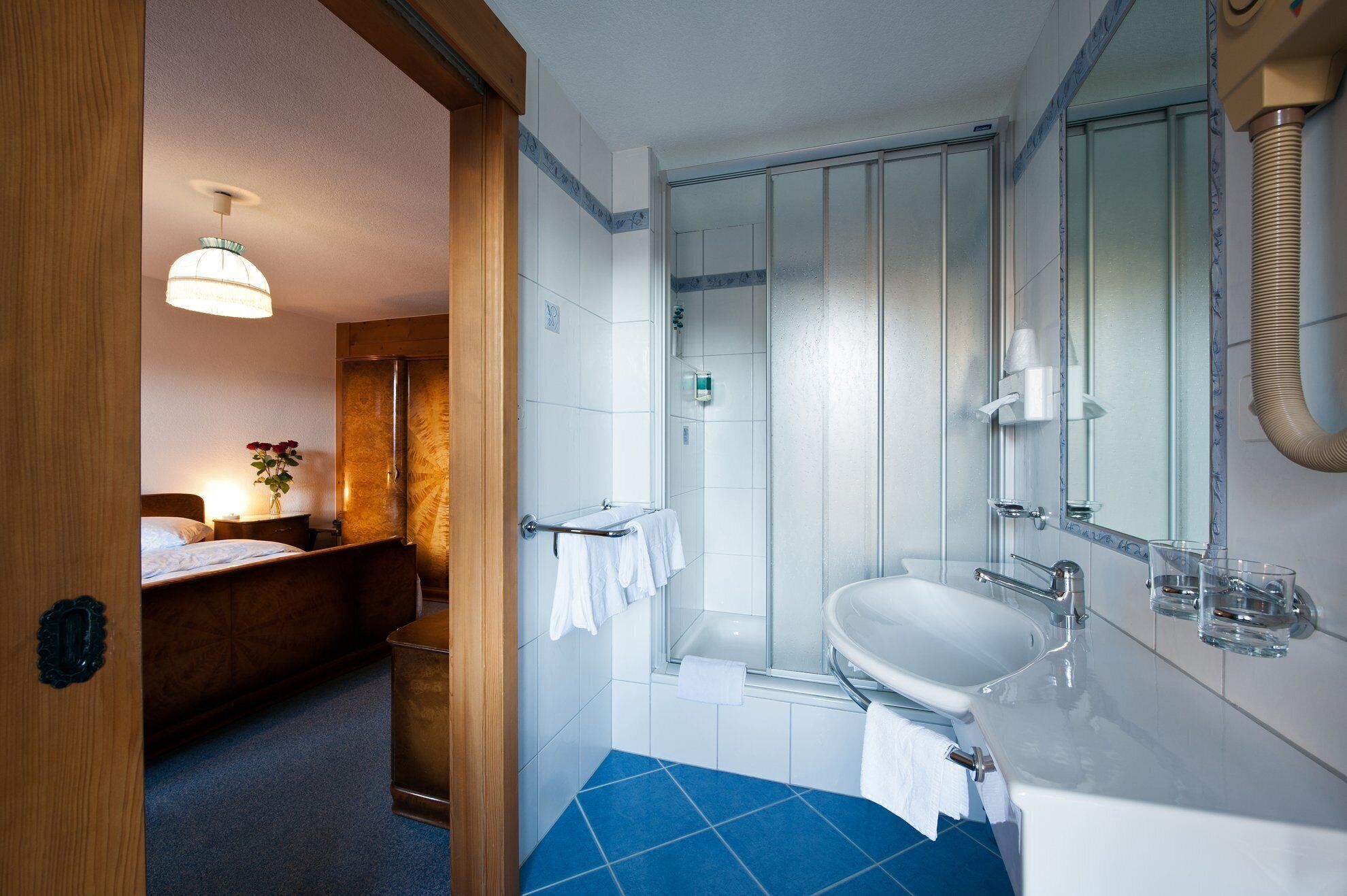 Un baño moderno con ducha, lavamanos y espejo.