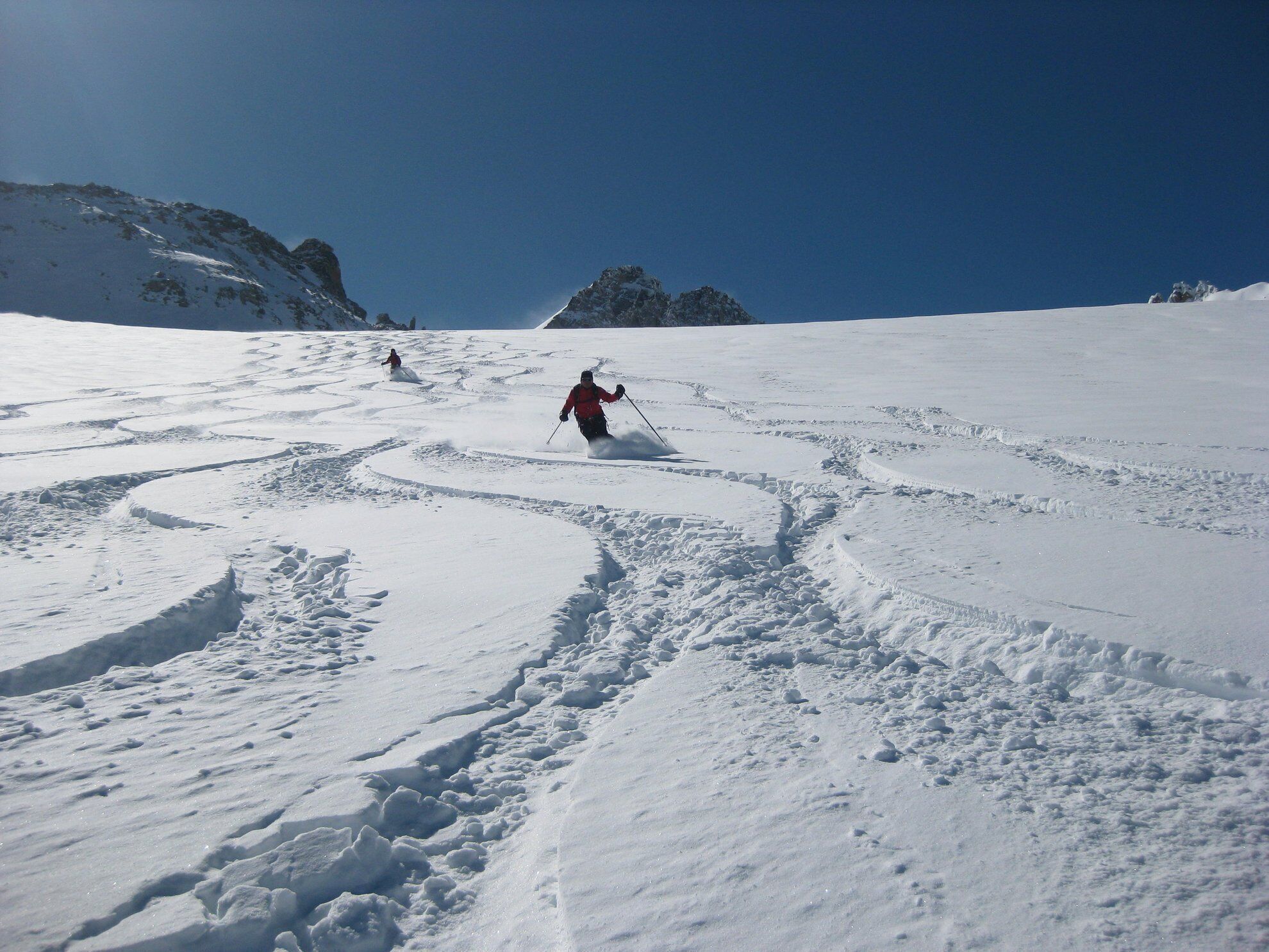 A snowy ski slope with skiers.
