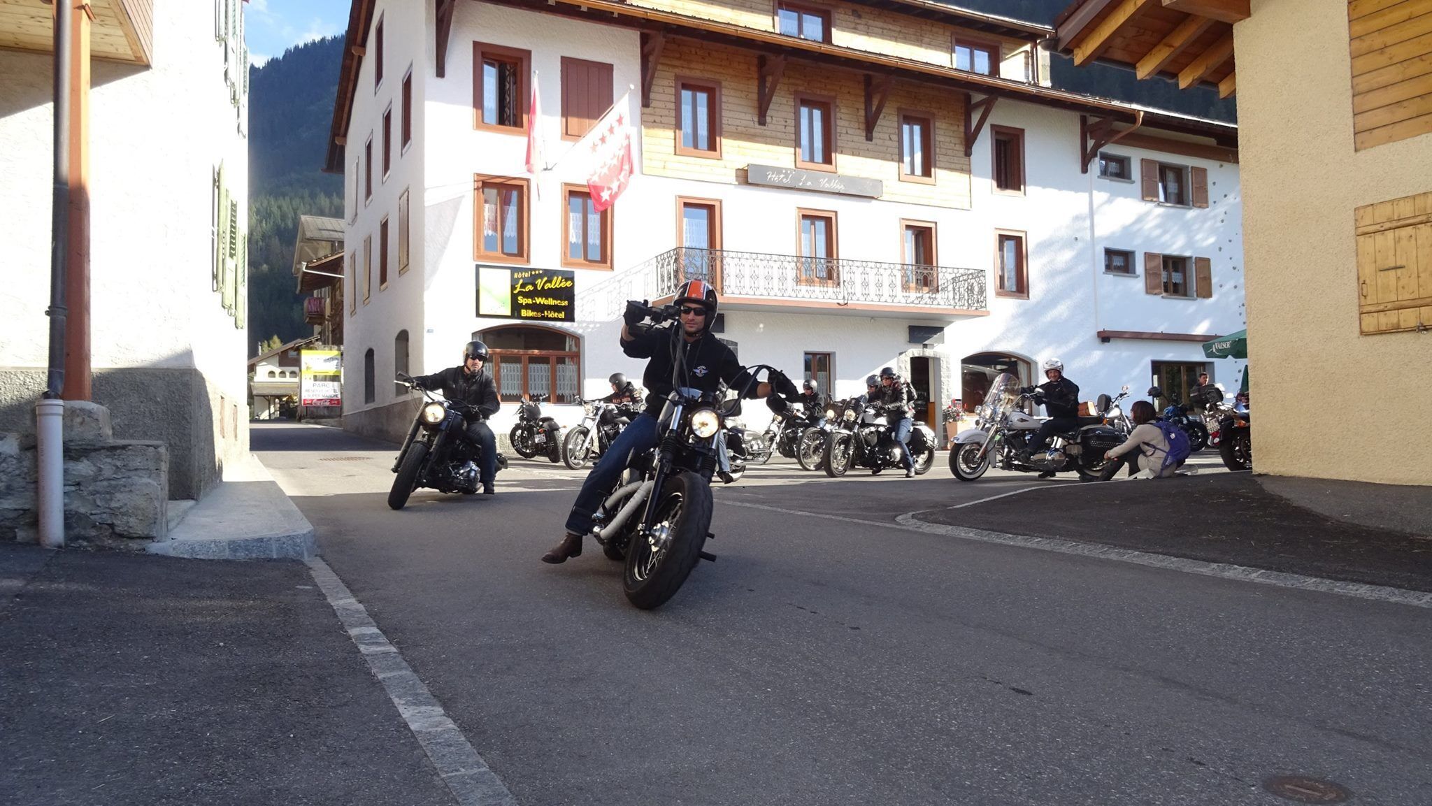 A street with multiple motorcycles parked along the side.