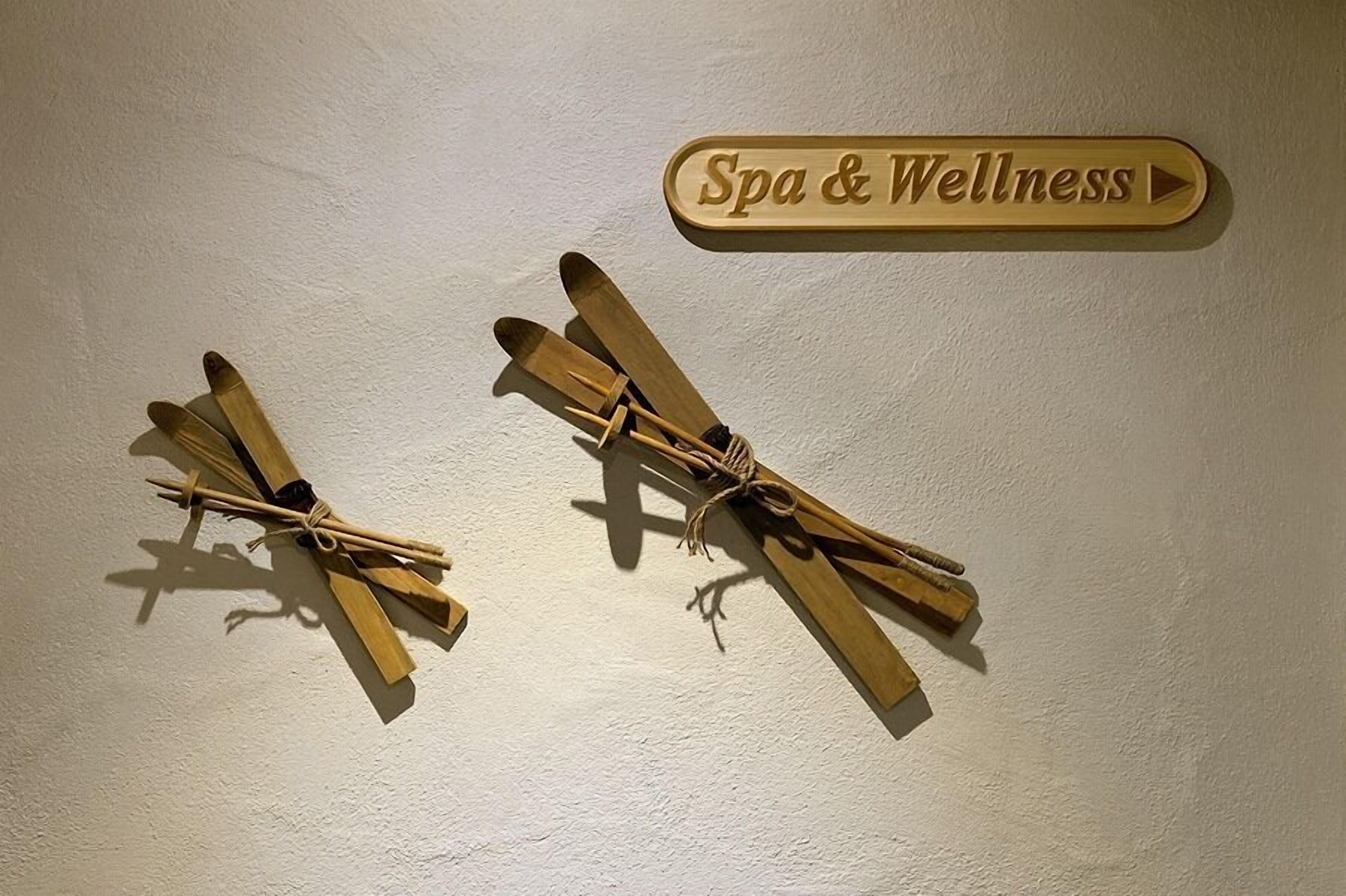 Zwei hölzerne Flugzeuge, an einer Wand befestigt, mit einem Schild darüber, auf dem 'Spa & Wellness' steht.
