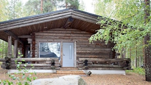 A rustic log cabin with a front porch, a door, and a small window. - Holiday Club Pyhäniemi (Kihnio)
