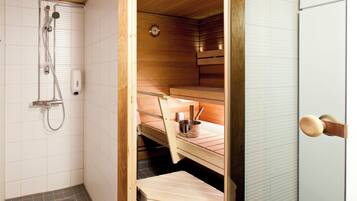 Een sauna met een houten bank, een douchekop en een klein tafeltje met een kom en lepel.