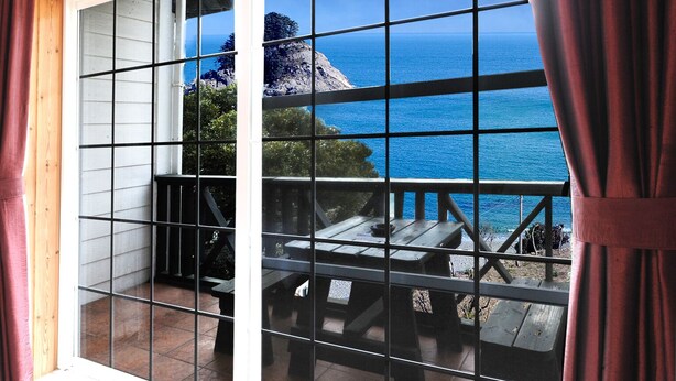 Un balcon avec vue sur l’océan et les falaises rocheuses.