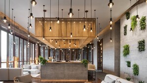 Ein modernes Interieur mit einer zentralen Sitzecke, hängenden Lampen und vertikalen Grünflächen an den Wänden.