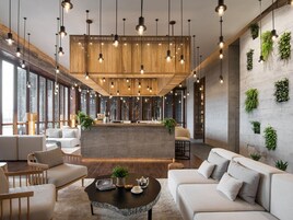 A modern interior with a central seating area, hanging lights, and vertical greenery on the walls.