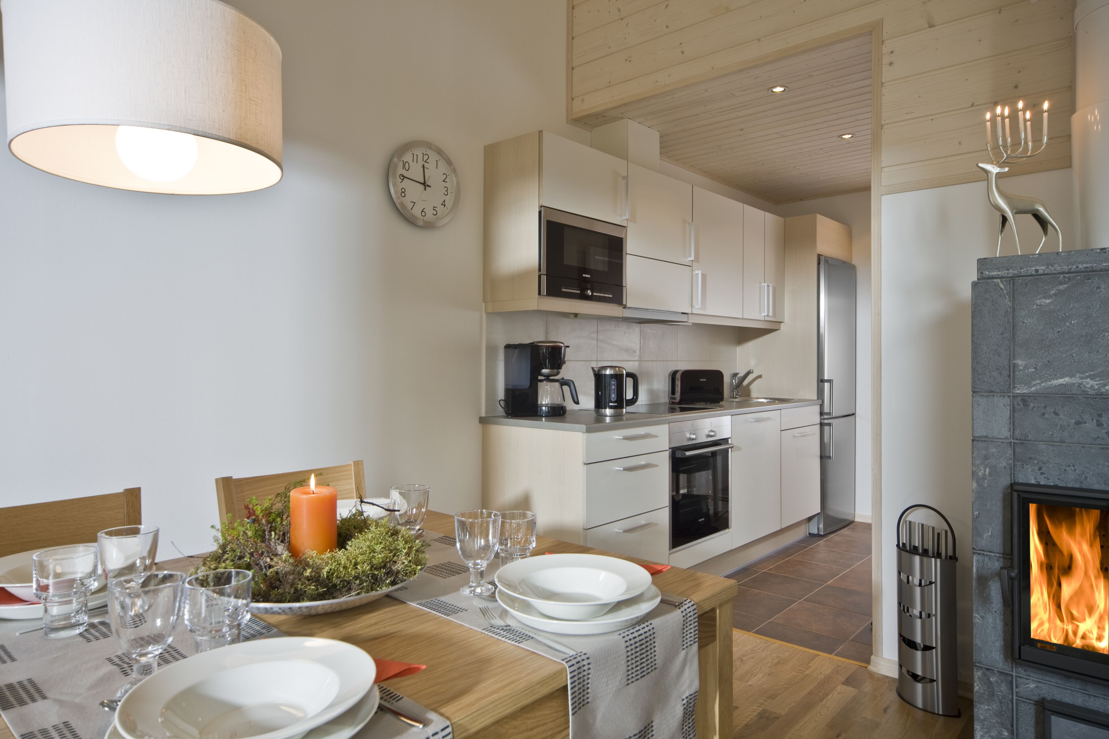 Una cocina moderna con armarios blancos, horno empotrado y chimenea.
