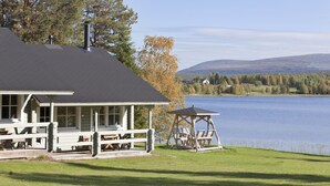 Un chalet au bord du lac, doté d’un espace pique-nique couvert et d’un quai.