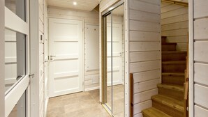 Un escalier avec des marches en bois et une rampe, menant à une porte dotée d’un panneau de verre.