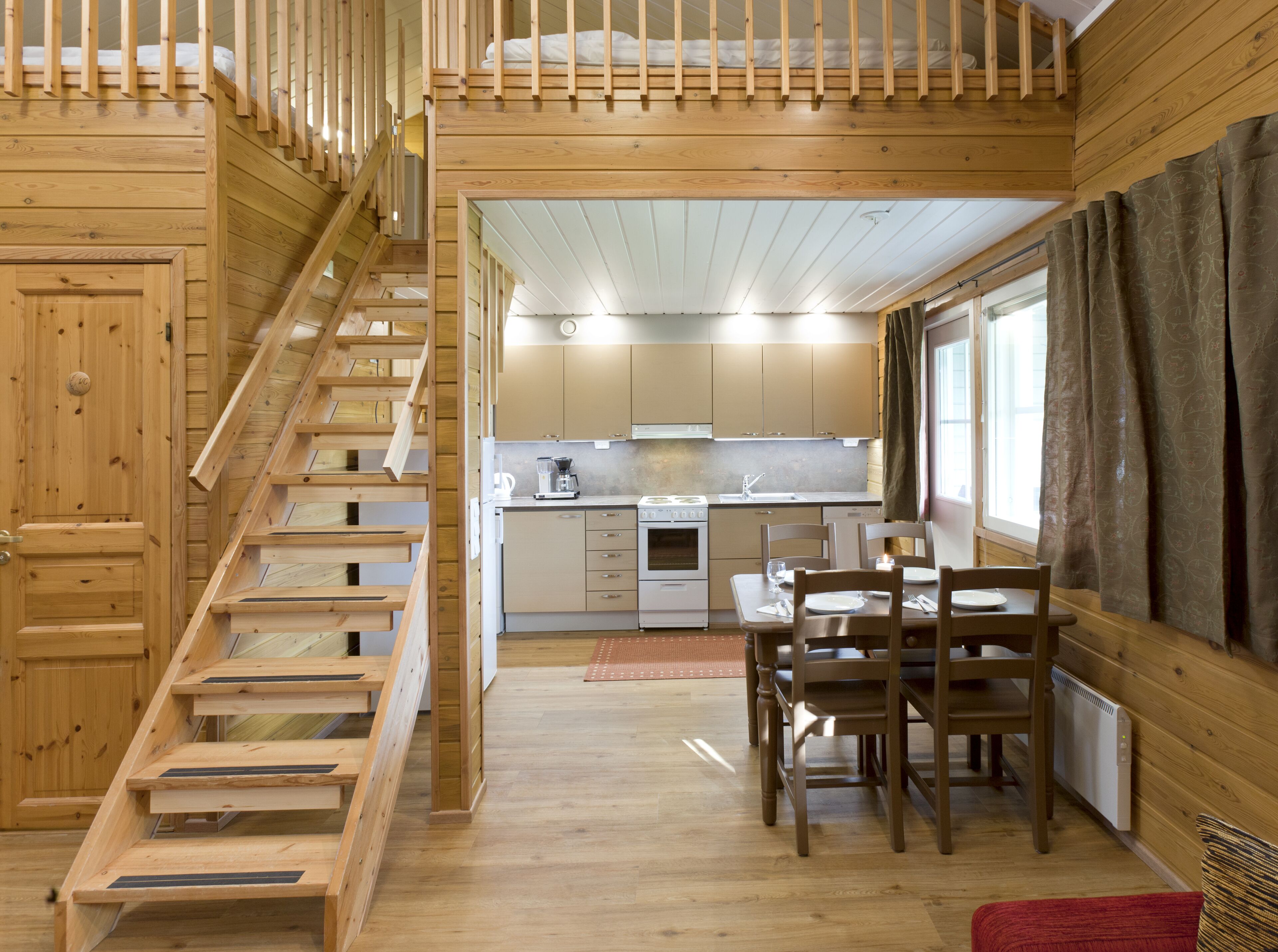Un interno in legno con una scala, una cucina e una sala da pranzo.